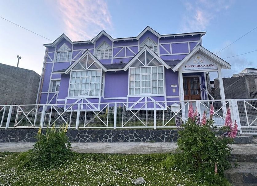 Hosteria Ailen in Ushuaia, purple guesthouse with white trim and fenced front yard