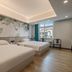 Qunxian Hotel, Guangzhou guest room with two beds, tropical wall mural, and city view window