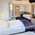 B&B Hotel Frankfurt City-Ost room with two single beds, desk, and wall mirror in Frankfurt am Main
