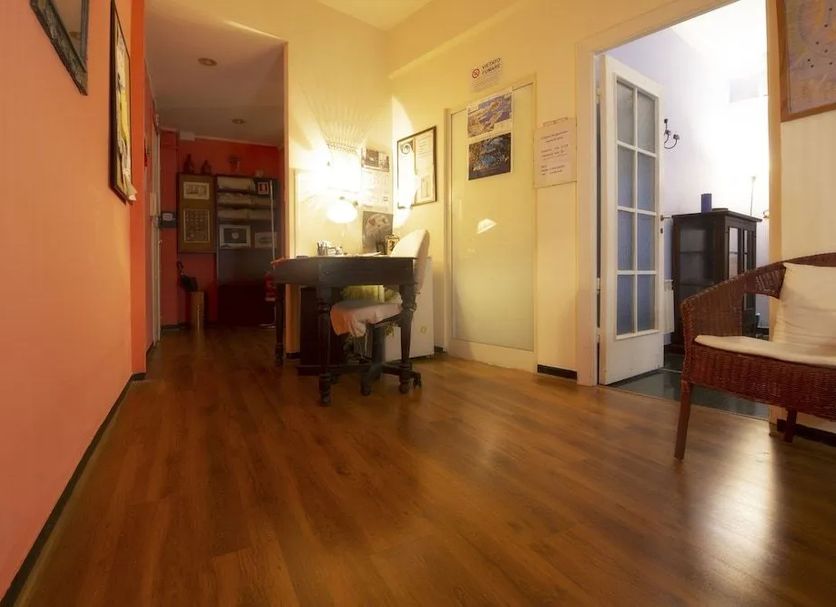 Il Riposo del Guerriero Guesthouse in Genoa hallway with wooden floors and desk area