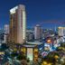 White Dolphin Hotel in Qinzhou at night, a tall tower overlooking the illuminated city skyline.