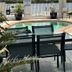River Sands Apartments Maroochydore outdoor pool area with glass patio table and chairs