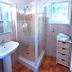 Résidence Les Cigales bathroom with shower, sink, window, and wicker drawer unit in Porto-Vecchio