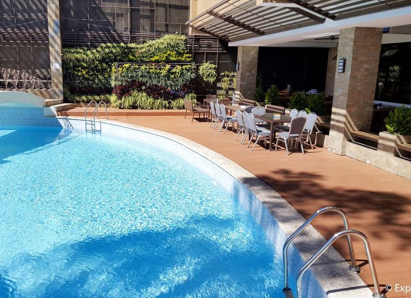 Newtown Plaza Hotel Baguio outdoor pool with lounge chairs and shaded dining terrace