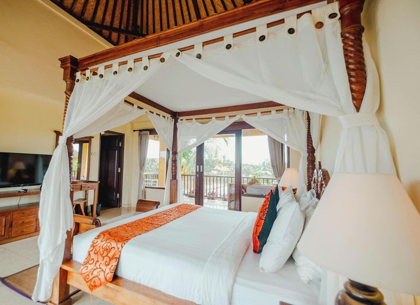 Sri Aksata Ubud Resort Ubud four-poster bed with balcony and tropical garden view