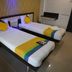 Hotel Naivedya in Aurangabad twin guest room with two single beds, colorful runners and pillows