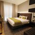 Threeland Hotel Pétange guest room with double bed, desk, window curtains, and modern shelving