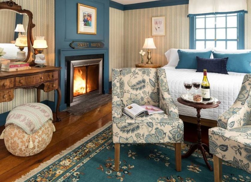 Waldo Emerson Inn, Kennebunk guest room with fireplace, patterned chairs, and a four-poster bed