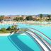 Club Hotel Marina Beach in Orosei: lagoon-style pool with arched bridges, palm island and mountain views