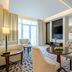 Riviera Rayhaan by Rotana Doha guest room with sitting area, TV wall and large window