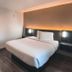 Motel 6 Sacramento West guest room with queen bed, desk, TV and bathroom vanity