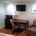 Arrowhead Mountain Inn in Lake Arrowhead room with desk, chair, armchair, TV and mini fridge