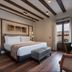 Áurea Toledo by Eurostars Hotel company guest room with king bed, bench, and balcony doors in Toledo