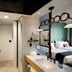Arrive Memphis guest room with black-framed glass shower and twin sink vanity in Memphis