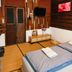 Songphuamia Guesthouse in Chiang Khan guest room with twin beds, wall TV, and wooden paneled walls