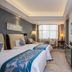 Century Palace Hotel Huiyang in Huizhou guest room with twin beds, desk, and large window