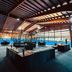 Aparthotel Baden in Baden: modern indoor rooftop lounge with seating, glass walls and pool area