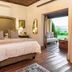 La Plume Boutique Hotel & Spa in Oudtshoorn bedroom with garden-view doorway and wooden floors