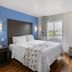SureStay Plus by Best Western Niagara Falls East room with king bed, blue accent wall, and window view