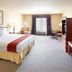 Holiday Inn Express & Suites Kerrville By IHG guest room with king bed, desk, chair, and window seating