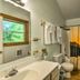 Bathroom at Nantahala Cabins in Bryson City with sink, toilet, window, and forest-themed shower curtain