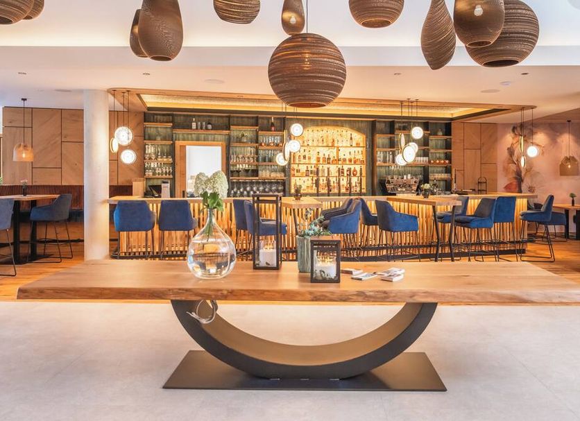 Ferienhotel Sonnenhof in Zell am Ziller, stylish hotel bar and lounge with blue chairs and pendant lights