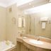 Yene hue Puerto Madryn bathroom with bathtub, glass shower, sink, towel rack and beige tile