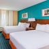 Fairfield Inn & Suites by Marriott Galesburg guest room with two beds, desk, and colorful accent wall