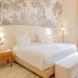 Château De Noirieux, Briollay: elegant bedroom with king bed, toile wallpaper, and tall window with drapes