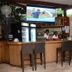 Elite Hotel Port Au Prince bar with stools, TV, mini fridge and drink dispenser