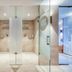 Hotel Leipziger Hof in Innsbruck: modern glass shower spa bathroom with marble tile and dual stalls