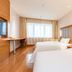 Ji Hotel Urumqi Hongshan guest room with two single beds, desk, and large window in Ürümqi