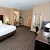 Cobblestone Inn & Suites - Denison guest room with king bed, desk and vanity in Denison