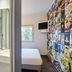hotelF1 Évry A6 room with bed, wall-mounted TV and shower sink area in Évry