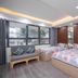Ann's Hotel & Apartment in Hanoi room with two beds, sofa, large windows and wood-paneled wall