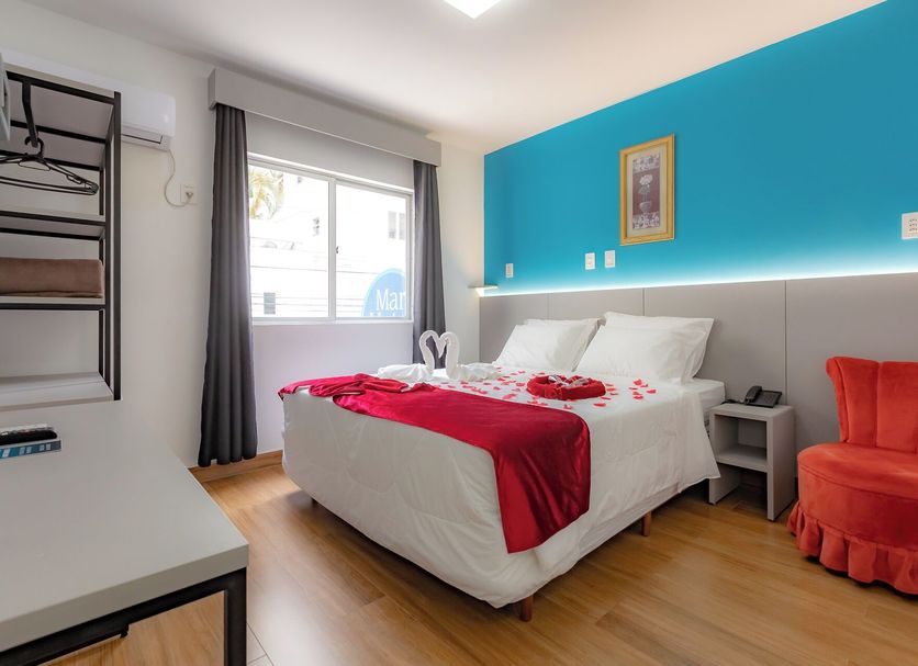 Mar Hotel room in Balneário Camboriú with double bed, blue accent wall and orange chair