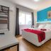 Mar Hotel room in Balneário Camboriú with double bed, blue accent wall and orange chair