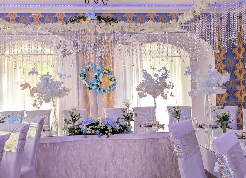 Rezydencja Dwór Górny in Nowa Ruda: elegant banquet table with floral arch and draped reception décor
