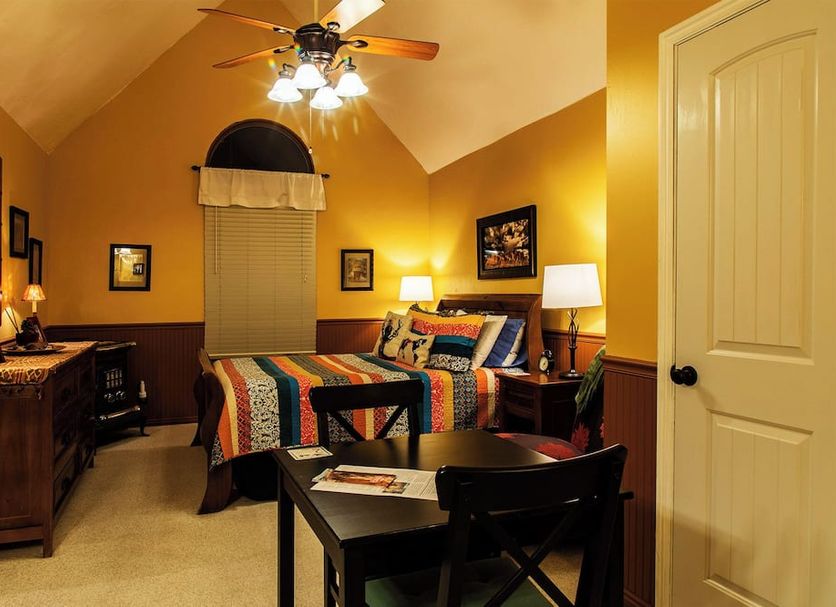 2 Cranes Inn - Zion bedroom in Rockville with colorful quilt, ceiling fan, and arched window