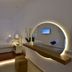 Margie Mykonos Hotel bedroom with circular LED-lit mirror and minimalist seating in Mykonos