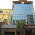 Hotel Gulshan International in Kolkata with a glass-front exterior and palm trees at the entrance