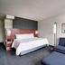 Courtyard by Marriott Johnson City guest room with king bed, blue sofa and abstract wall art