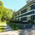Hotel de Stoppelberg in Beekbergen, exterior of a green two-story lodge-style building surrounded by trees