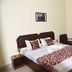 Hotel Lumbini International, Bodh Gaya: double bed with patterned runner, chairs, and wardrobe in guest room