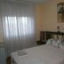 Pension Mari Asun in Pamplona guest room with double bed, sheer curtains and wall art