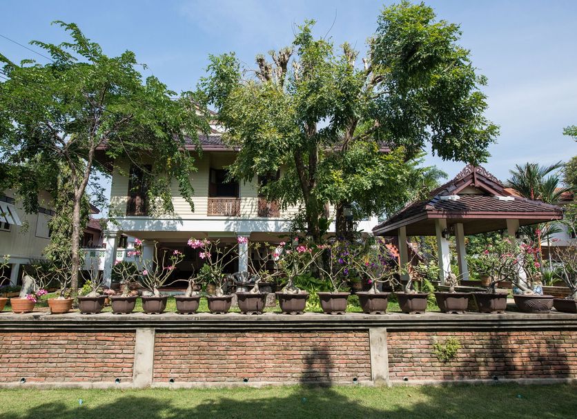 Phuttal Residence in Ayutthaya with garden-lined brick wall and traditional pavilion