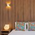 Next Inn, Portimão room with wood-paneled wall, colorful pillows, and bedside lamps