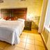La Ermita de Santa Lucia in Antigua, bedroom with double bed, wooden headboard, bedside lamps and tiled floor