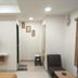 Abirami Inn Kumbakonam room with wall-mounted TV, seating area, desk and recessed lighting