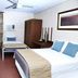 Hotel Kununurra room with two beds, ceiling fan, window AC, and view of greenery in Kununurra